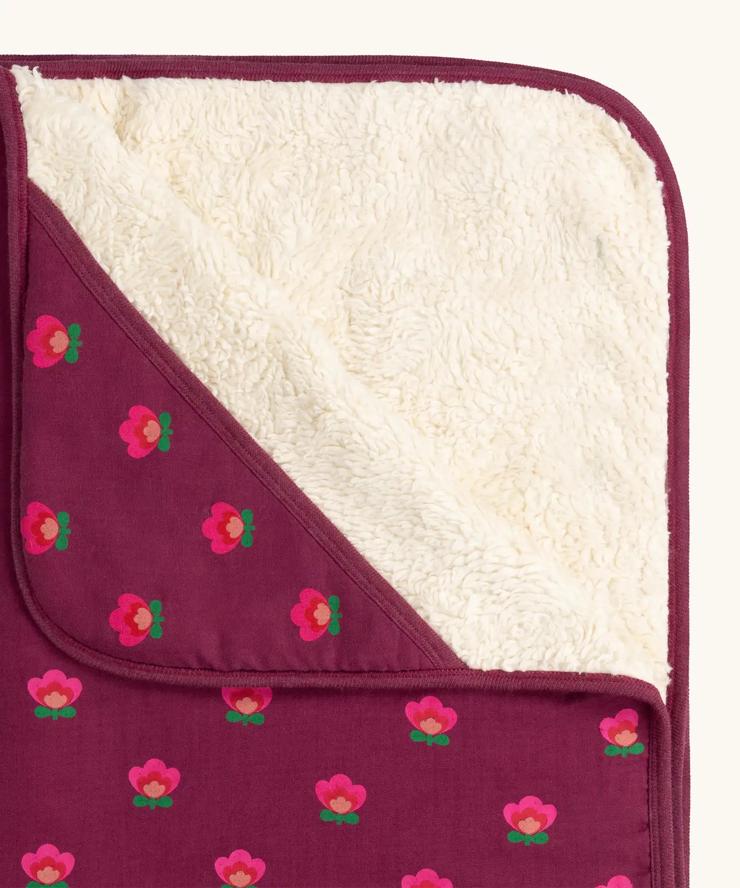 Close up of the fleece on the Little Green Radicals pink flowers organic cotton sherpa hooded baby blanket.