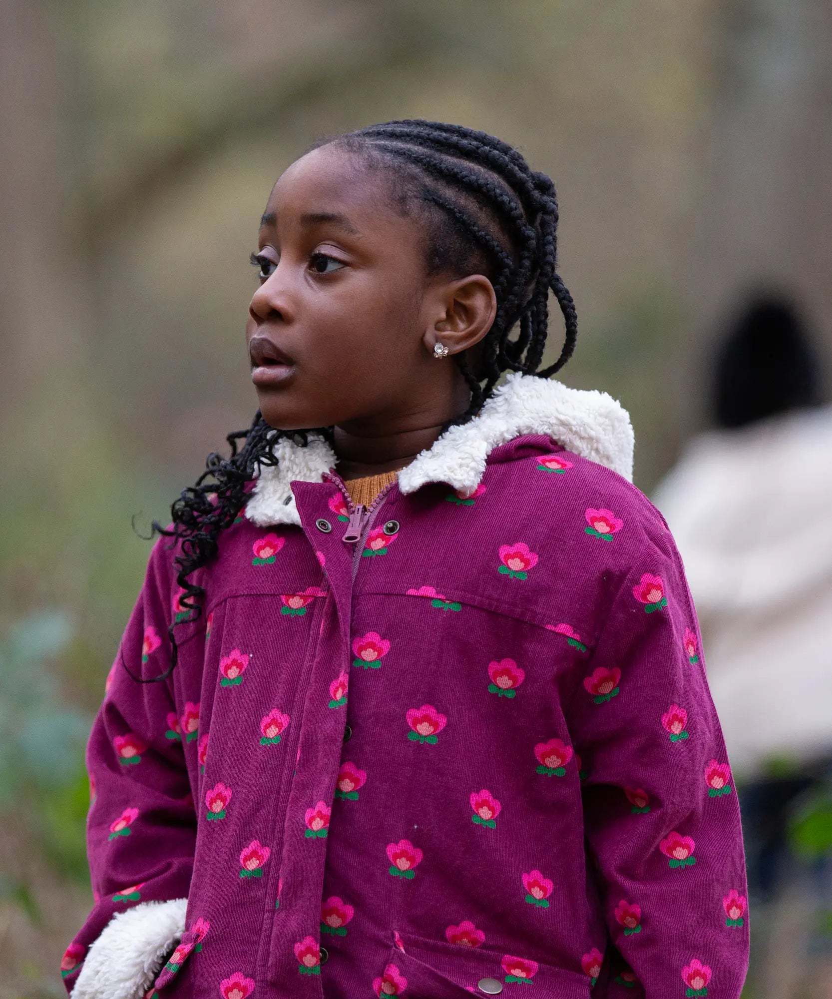 Child wearing a Little Green Radicals pink flowers purple organic cotton sherpa toasty coat.