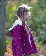 Child wearing a Little Green Radicals pink flowers purple organic cotton sherpa toasty coat.
