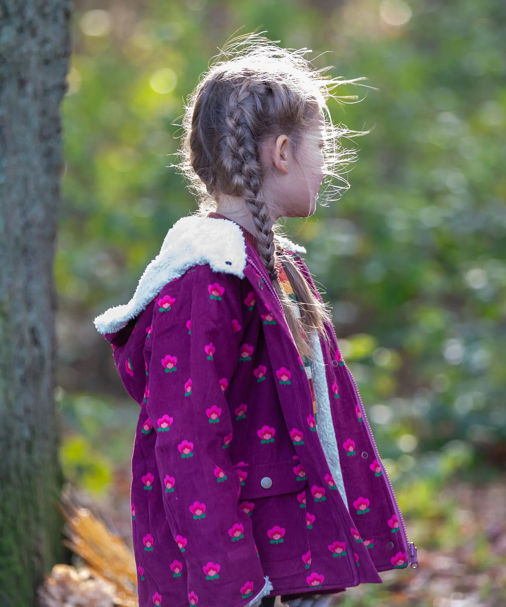 Child wearing a Little Green Radicals pink flowers purple organic cotton sherpa toasty coat.