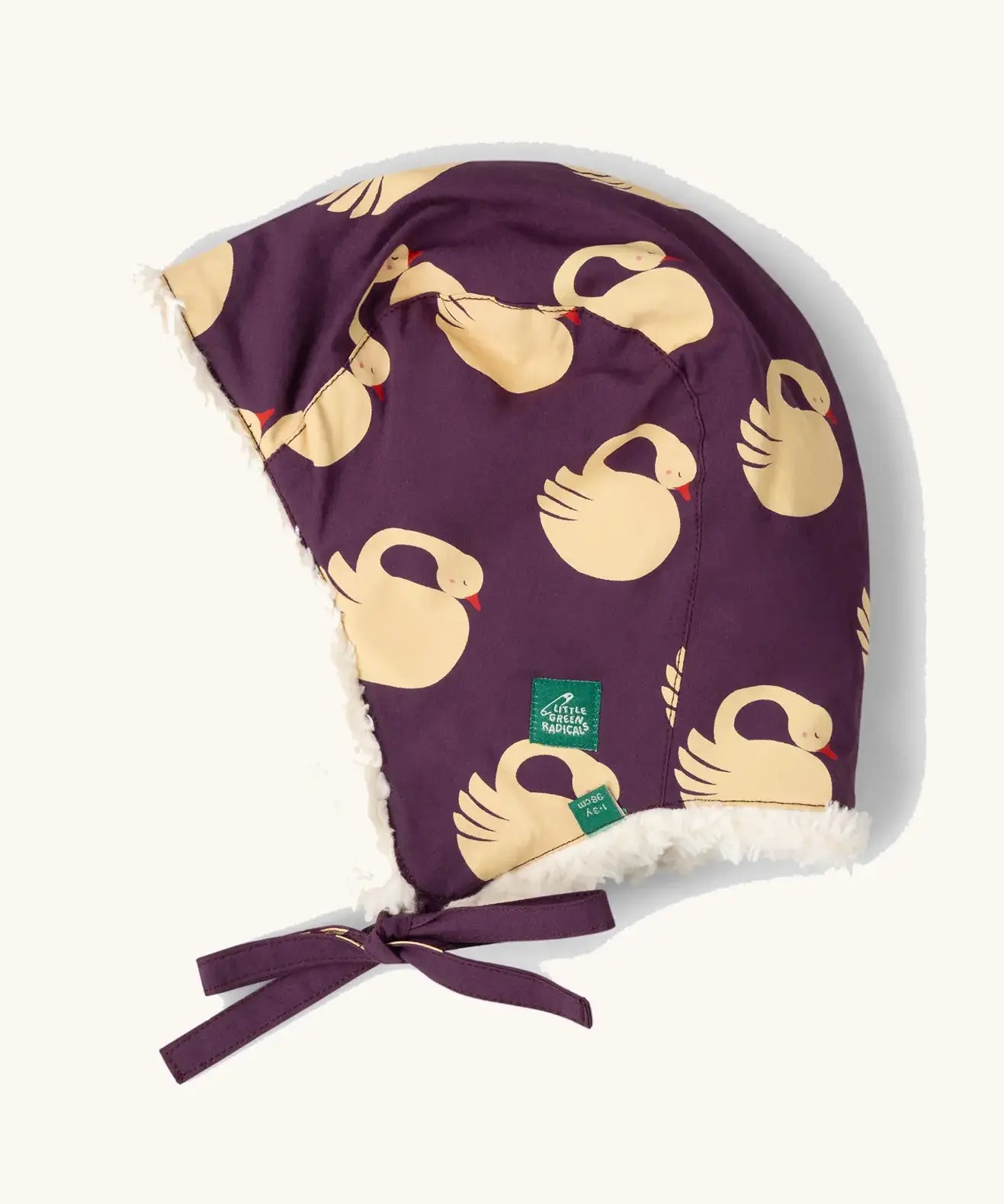Little Green Radicals  sleeping swans print sherpa fleece lined purple hat. Purple organic cotton sherpa fleece lined flapper style hat with a sleeping swans print. 