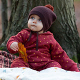 A baby wearing the Little Green Radicals Organic Cotton Quilted Snug Suit with a Red Stars design. This snug suit is a part of a wide range of organic cotton clothing for children available here at Babipur. 