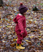 A child wearing the Little Green Radicals Organic Cotton Quilted Snug Suit with a Red Stars design. This snug suit is a part of a wide range of organic cotton clothing for children available here at Babipur. 