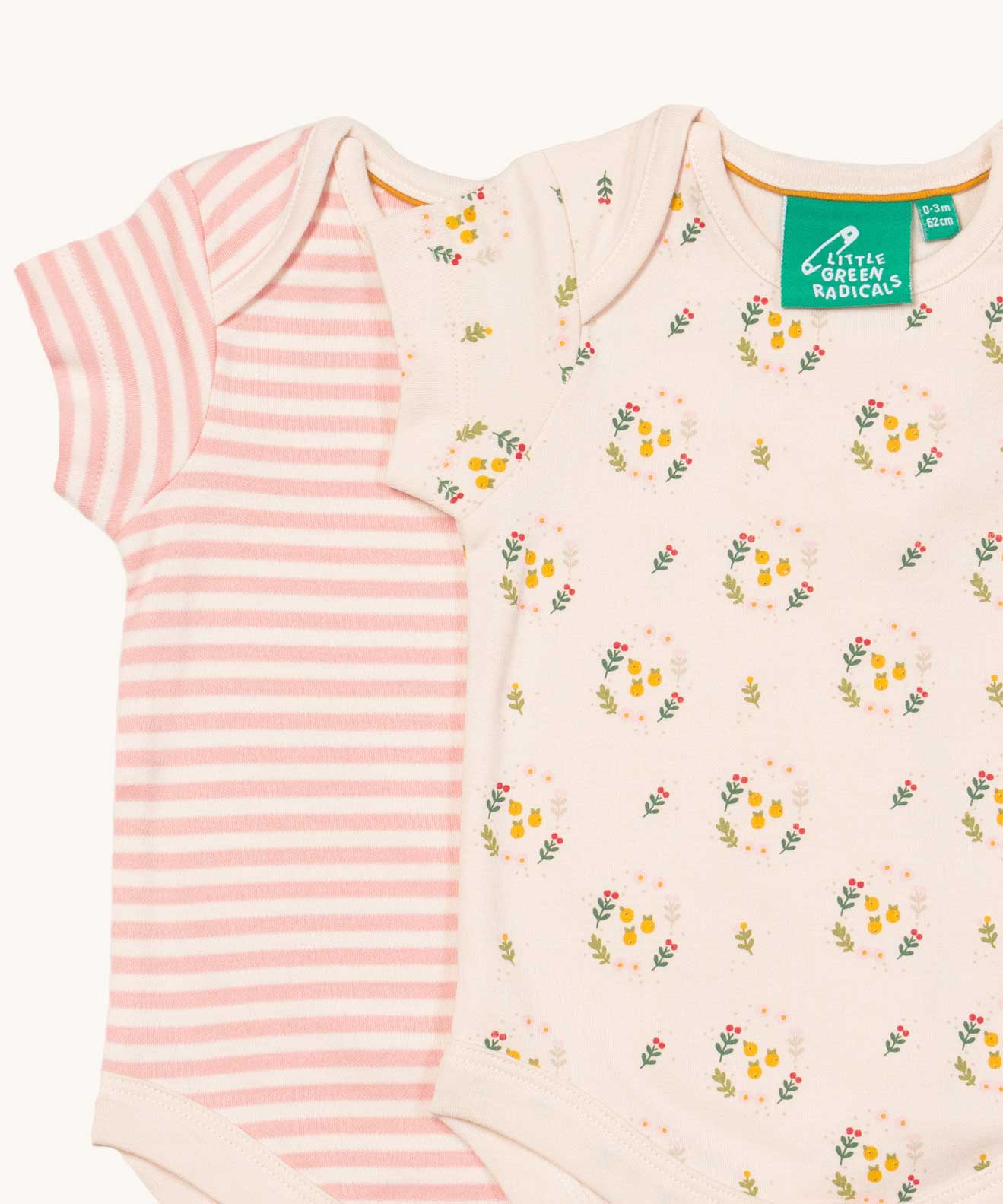 A close up of the 2 pack of Little Green Radicals Quince Flowers Baby Body Set. One vest has a pink and white stripe with the other vest featuring an all over quince flower print. These short sleeved baby best are part of a wide range of organic cotton baby clothes available at Babipur. 