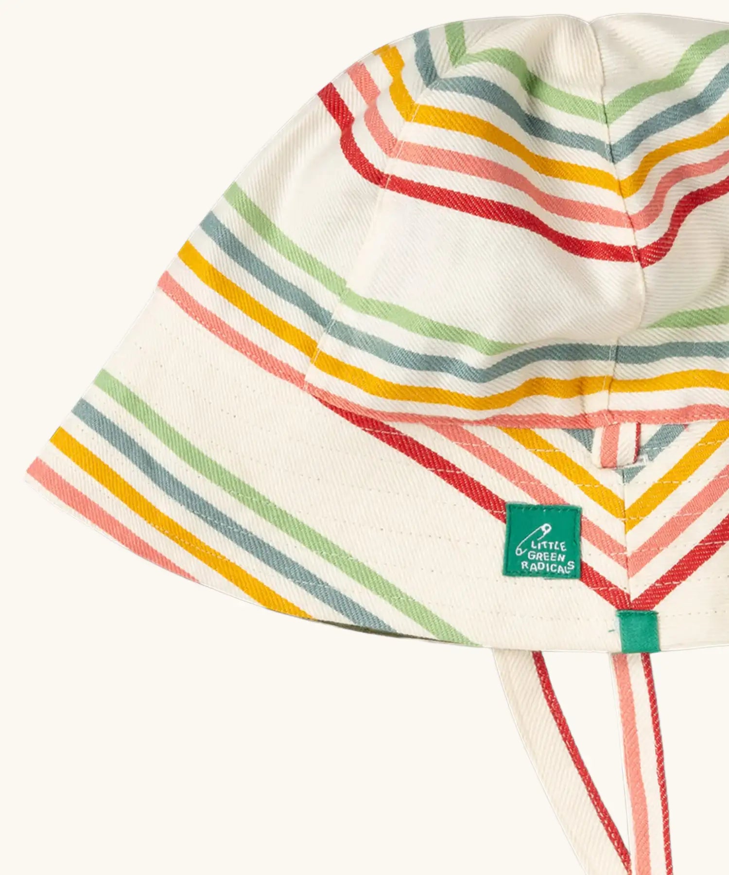 Close up of the Little Green Radicals cream rainbow stripe reversible organic cotton sunhat. Red, pink, yellow blue and green stripes on a cream background.