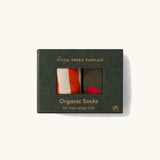 Little Green Radicals red apple organic cotton boot socks in a 2 pack in the cardboard gift box packaging. One dark green pair with red apple print, one white and orange stripes.