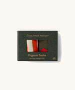 Little Green Radicals red apple organic cotton boot socks in a 2 pack in the cardboard gift box packaging. One dark green pair with red apple print, one white and orange stripes.