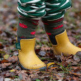 Child wearing the Little Green Radicals red apple terry boot socks with yellow gold wellington boots. 