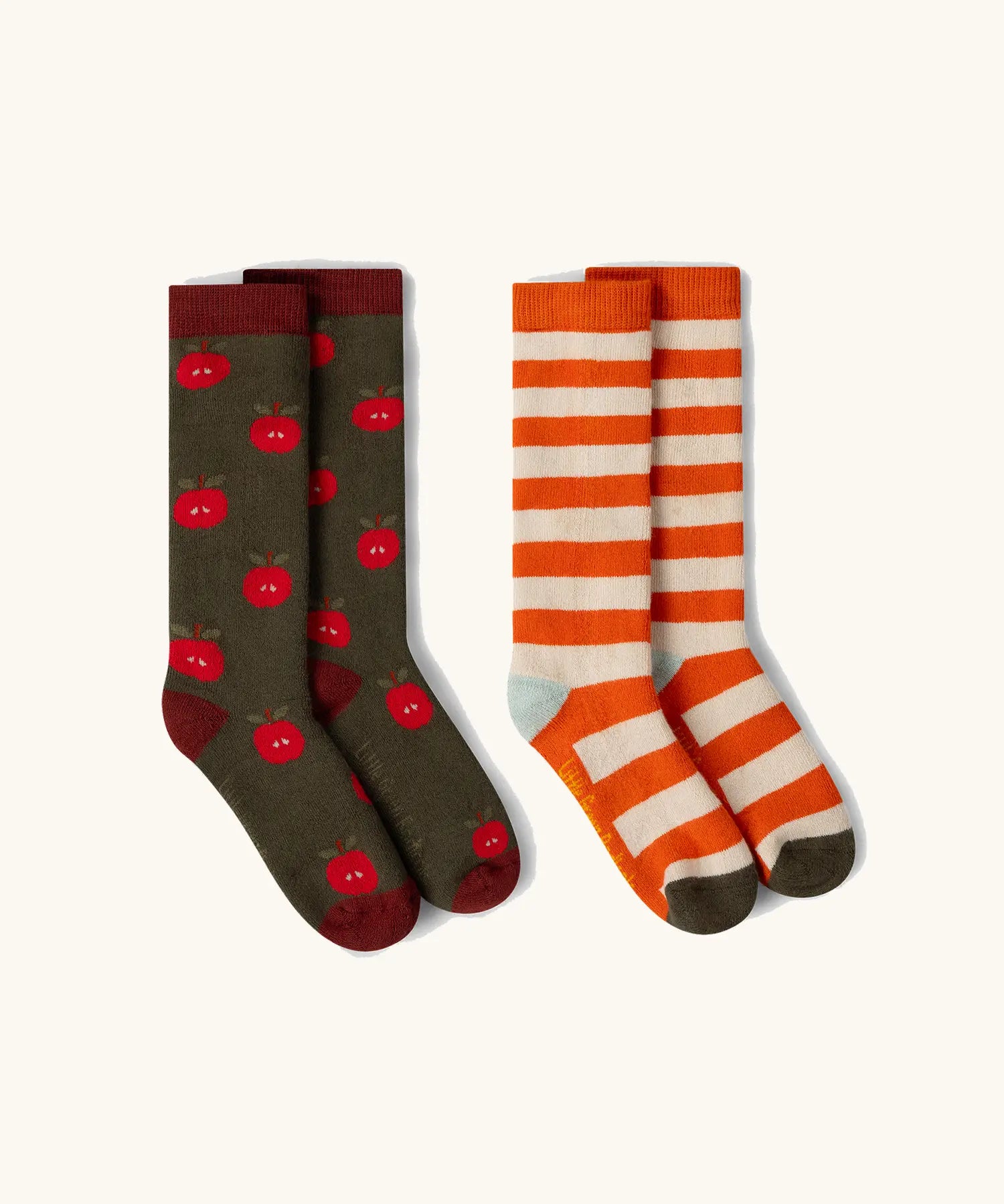Little Green Radicals red apple organic cotton boot socks in a 2 pack. One dark green pair with red apple print, one white and orange stripes.