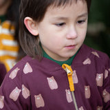 A close up of a child wearing the  Little Green Radicals Reversible Easy Rider Jacket on the Brown Bears print side. Little green Radicals have a wide range of organic cotton, Fairtrade children's clothing an outerwear available here at Babipur