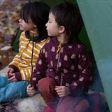 Two children sitting in a tent in the forest. Both are wearing the Little Green Radicals Reversible Easy Rider Jacket. One on the Brown Bears print side the other on a yellow gold and white stripe side. Little green Radicals have a wide range of organic cotton, Fairtrade children's clothing an outerwear available here at Babipur