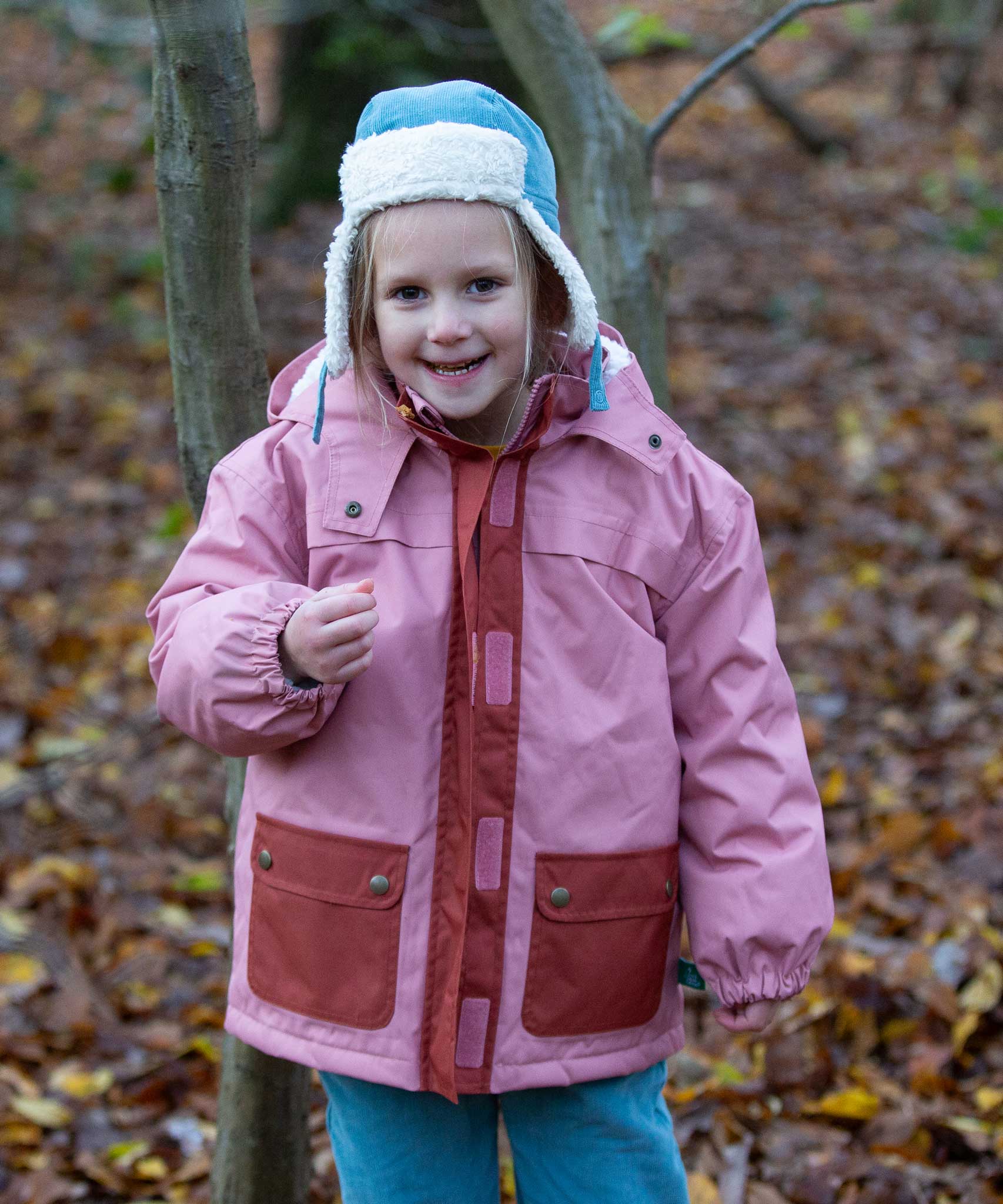 A child wearing the Little Green Radials sherpa fleece cosy hat in pale blue. This hat is a part of a wide range of organic cotton clothing and accessories for children available here at Babipur. 