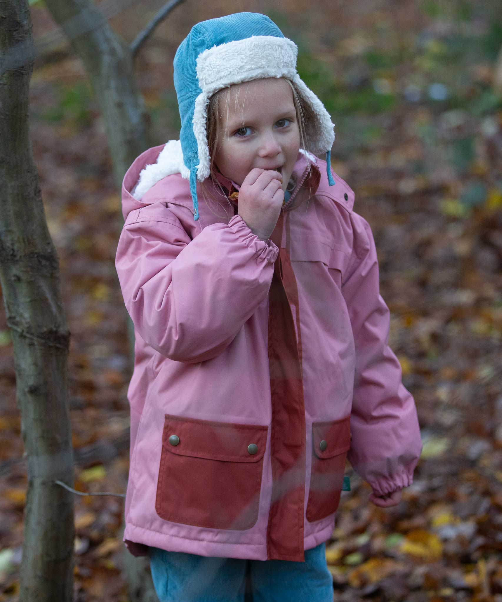 A child wearing the Little Green Radials sherpa fleece cosy hat in pale blue. This hat is a part of a wide range of organic cotton clothing and accessories for children available here at Babipur. 