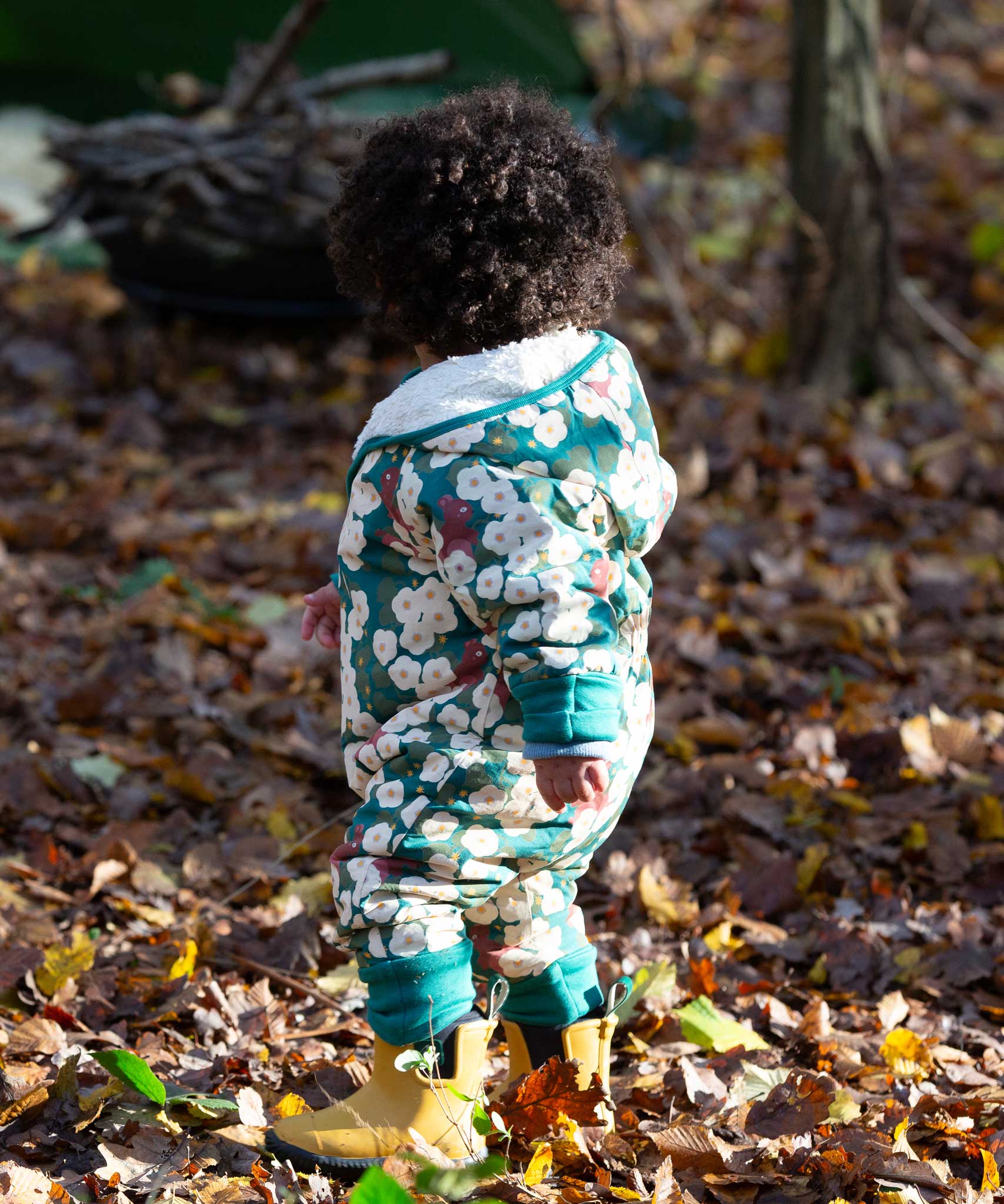 A child wearing the Little Green Radicals Organic Cotton Sherpa Fleece Snowsuit in the Hedgerow design.This organic cotton suit is a part of a wide range of organic cotton clothing for children available here at Babipur. 