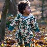 A child wearing the Little Green Radicals Organic Cotton Sherpa Fleece Snowsuit in the Hedgerow design.This organic cotton suit is a part of a wide range of organic cotton clothing for children available here at Babipur. 
