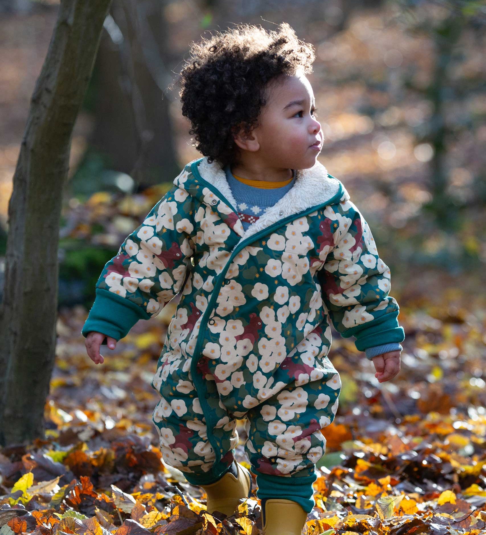 A child wearing the Little Green Radicals Organic Cotton Sherpa Fleece Snowsuit in the Hedgerow design.This organic cotton suit is a part of a wide range of organic cotton clothing for children available here at Babipur. 
