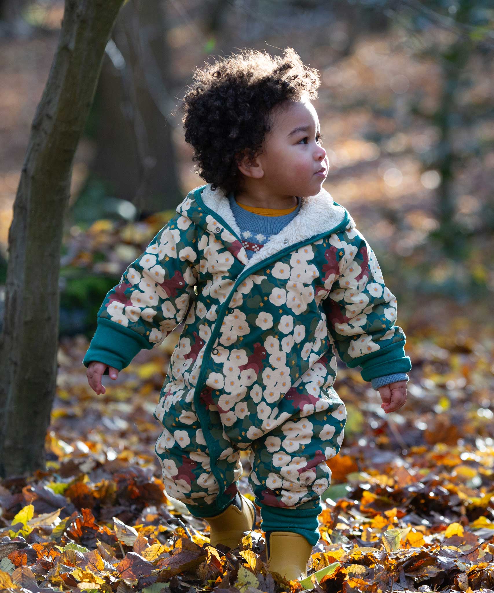 A child wearing the Little Green Radicals Organic Cotton Sherpa Fleece Snowsuit in the Hedgerow design.This organic cotton suit is a part of a wide range of organic cotton clothing for children available here at Babipur. 
