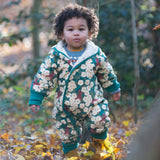 A child wearing the Little Green Radicals Organic Cotton Sherpa Fleece Snowsuit in the Hedgerow design.This organic cotton suit is a part of a wide range of organic cotton clothing for children available here at Babipur. 