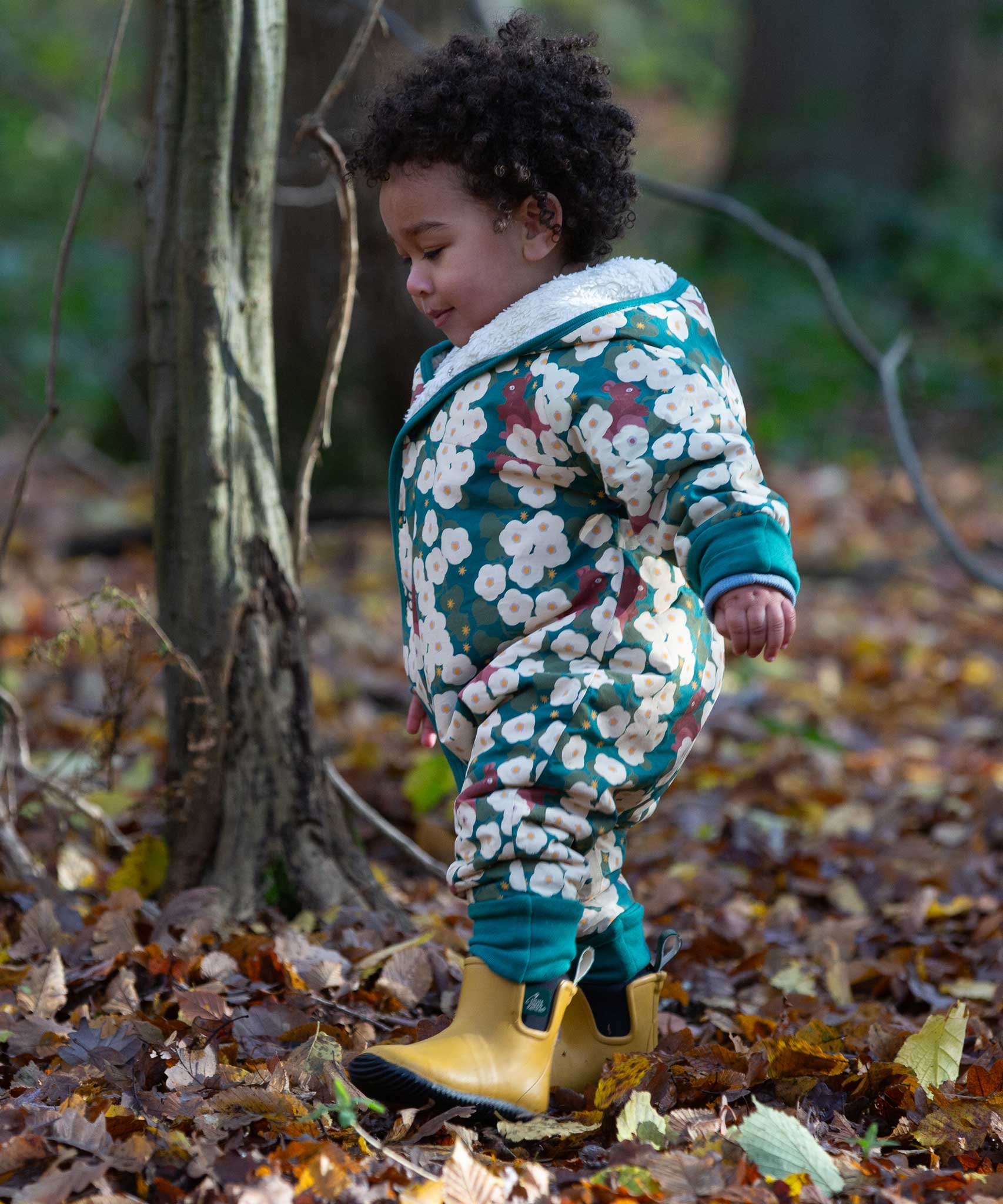 A child wearing the Little Green Radicals Organic Cotton Sherpa Fleece Snowsuit in the Hedgerow design.This organic cotton suit is a part of a wide range of organic cotton clothing for children available here at Babipur. 