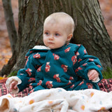 A baby wearing the Little Green Radicals Sherpa Fleece Snowsuit , a Organic Cotton suit with a Red Foxes all over print on a dark green background. This lined snowsuit is a part of a wide range of organic cotton clothing for children available here at Babipur. 