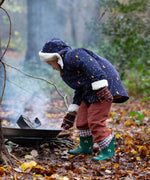A child wearing the Little Green Radicals Kids Dark Night design Organic Sherpa lined Toasty Coat. This warm coat is navy with a yellow moon and stars print all over with a white sherpa fleece lining. This coat is a part of a wide range of organic cotton clothing for children available here at Babipur. 