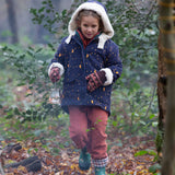 A child wearing the Little Green Radicals Kids Dark Night design Organic Sherpa lined Toasty Coat. This warm coat is navy with a yellow moon and stars print all over with a white sherpa fleece lining. This coat is a part of a wide range of organic cotton clothing for children available here at Babipur. 
