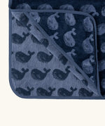 Little Green Radical hooded towel in navy blue with a repeating whale design showing contrast inner lining 