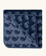 Little Green Radicals GOTS organic cotton hooded towel in navy blue with a repeating whale design folded into a square
