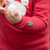 Close up of the little tree embroidery details on the sleeve of the Little Green Radicals sleeping swan applique long sleeve organic cotton top in red.