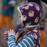 Child wearing the Little Green Radicals soft blue striped long sleeve t-shirt with purple sleeping swan filet and hat.