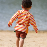 Back of child wearing the Little Green Radicals sorbet striped UPF 50 sunsafe long sleeve rash vest with dark red swim shorts.