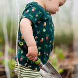 Child wearing the Little Green Radicals Spring garden organic cotton playset outfit. Repeat pattern green t-shirt and green and cream striped joggers. 