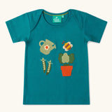 Little Green Radicals Spring garden embroidered organic cotton green t-shirt. Features 4 embroidered elements, a white watering can, peas in their pods, a bee and a potted plant.