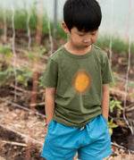 Child wearing the Little Green Radicals Summer rays sunshine short sleeve green organic-cotton t-shirt with blue shorts