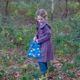 Child holding a Little Green Radicals  sun birds print blue recycled waterproof wet bag.