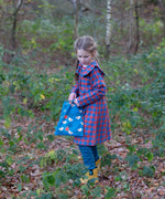 Child holding a Little Green Radicals  sun birds print blue recycled waterproof wet bag.
