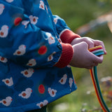 Close up of a child wearing a Little Green Radicals blue sun birds recycled waterproof adventure Winter coat.