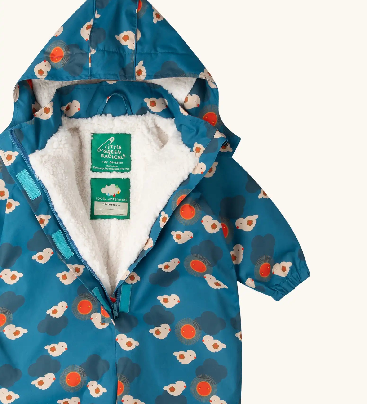 Close up of the Little Green Radicals sun birds recycled waterproof winter all in one suit unzipped showing the fleece lining. Blue background with white birds and orange sun. 