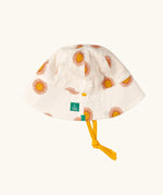 Little Green Radicals summer sun reversible cream sunhat shown on the repeat sunshine print side.