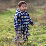 Young child wearing a Little Green Radicals sun folk blue sherpa fleece lined snowsuit.