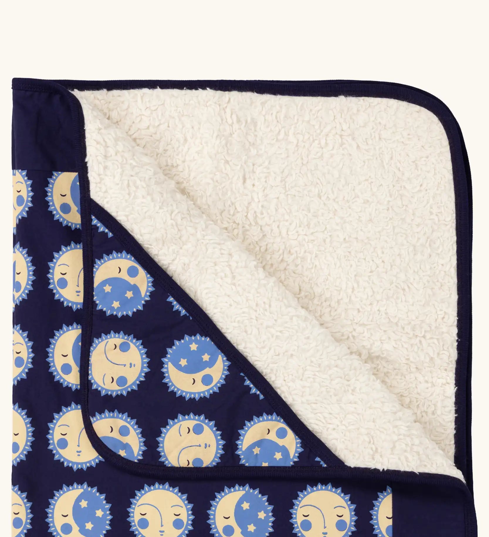 Close up of Little Green Radicals sun folk navy organic cotton sherpa hooded baby blanket . 