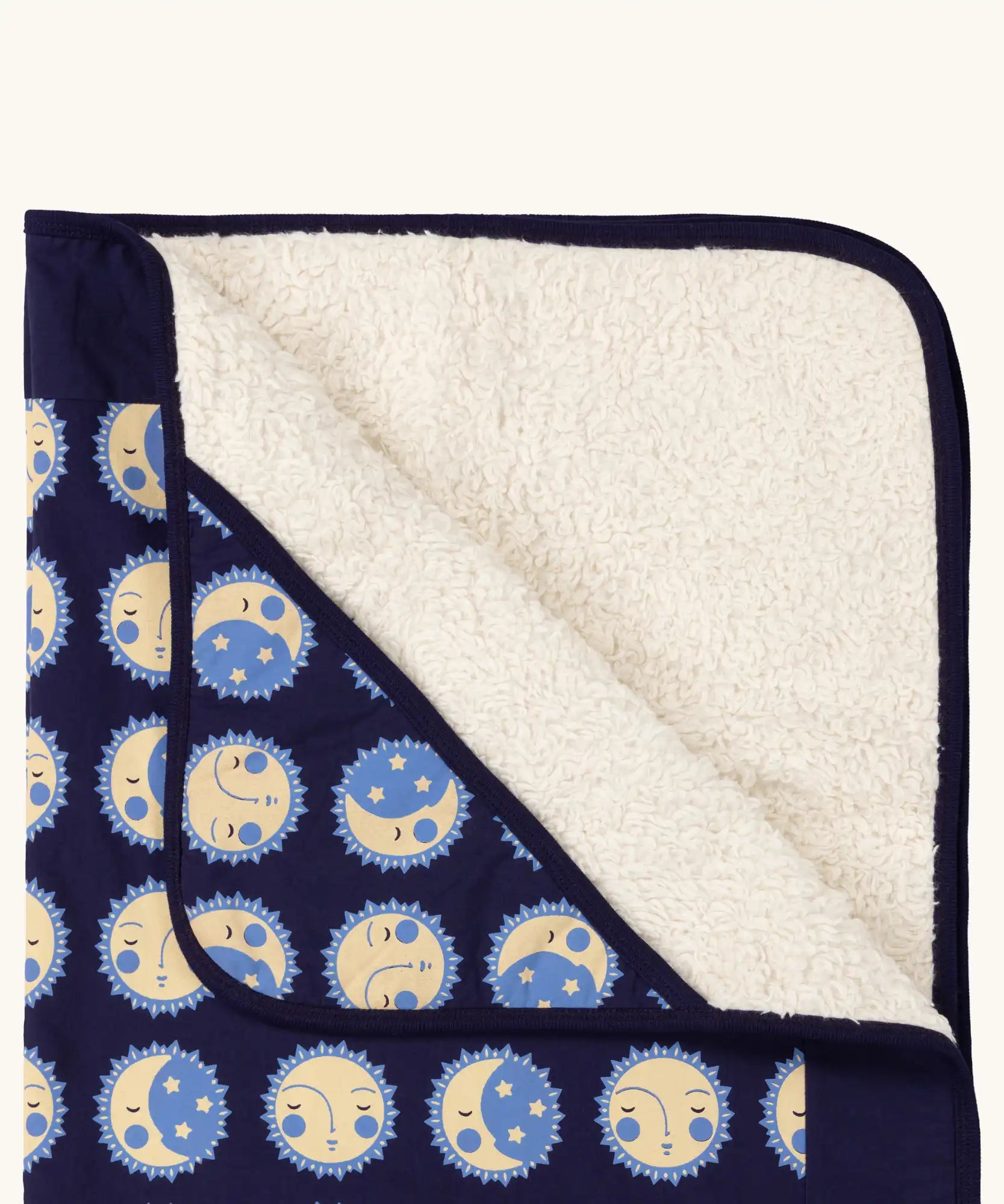 Close up of Little Green Radicals sun folk navy organic cotton sherpa hooded baby blanket . 