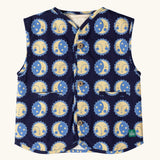 Little Green Radicals sun folk organic cotton sherpa fleece reversible gilet. Navy blue gilet with repeat sun and moon sun folk print on one side and sherpa fleece on the other. 