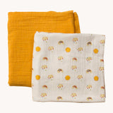 A Little Green Radicals Sunshine & Rainbows Organic Baby Muslin Set. A  2 Pack of muslin cloths, one is plain yellow gold and the other has an all over print featuring rainbows, sun and rainbow rain clouds. Little green Radicals have a wide range of organic cotton, Fairtrade children's clothing and outerwear available here at Babipur.