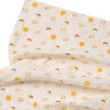 A close up of the rainbow and sunshine print on the muslin from the Little Green Radicals Sunshine & Rainbows Organic Baby Muslin Set. A  2 Pack of muslin cloths, one is plain yellow gold and the other has an all over print featuring rainbows, sun and rainbow rain clouds. Little green Radicals have a wide range of organic cotton, Fairtrade children's clothing and outerwear available here at Babipur.