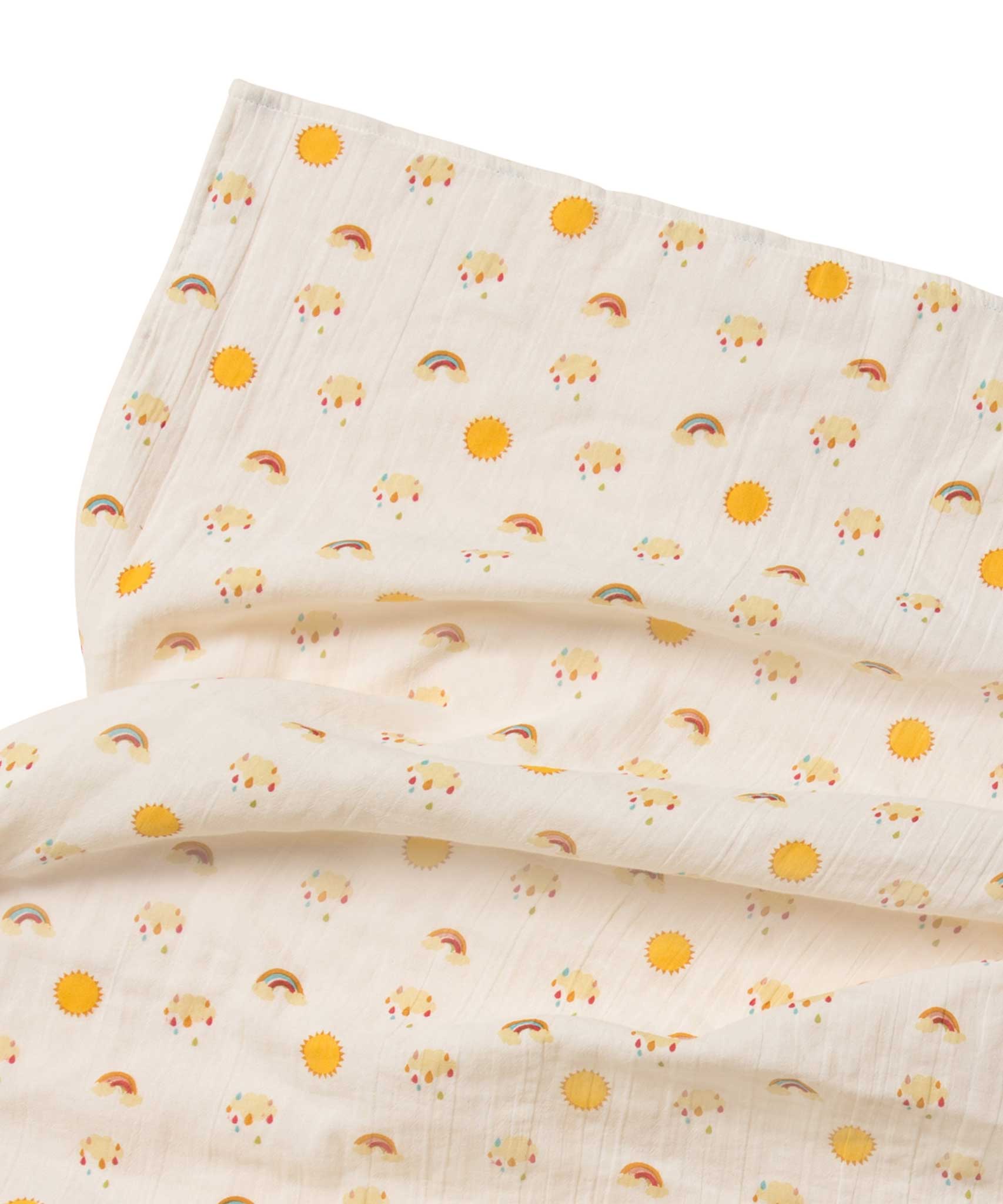 A close up of the rainbow and sunshine print on the muslin from the Little Green Radicals Sunshine & Rainbows Organic Baby Muslin Set. A  2 Pack of muslin cloths, one is plain yellow gold and the other has an all over print featuring rainbows, sun and rainbow rain clouds. Little green Radicals have a wide range of organic cotton, Fairtrade children's clothing and outerwear available here at Babipur.