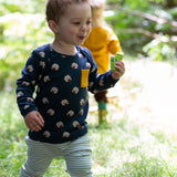 A child wearing the Little Green Radicals Kids' Organic Top and Joggers Playset featuring the Sleeping Sheep print on the top and a blue and white stripe on the joggers.  Little green Radicals have a wide range of organic cotton, Fairtrade children's clothing an outerwear available here at Babipur.