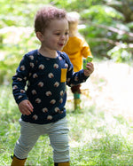 A child wearing the Little Green Radicals Kids' Organic Top and Joggers Playset featuring the Sleeping Sheep print on the top and a blue and white stripe on the joggers.  Little green Radicals have a wide range of organic cotton, Fairtrade children's clothing an outerwear available here at Babipur.