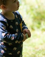 A close up of a child wearing the Little Green Radicals Kids' Organic Top and Joggers Playset with sleeping sheep print. Little green Radicals have a wide range of organic cotton, Fairtrade children's clothing an outerwear available here at Babipur.