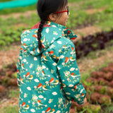 Back of a child wearing the Little Green Radicals turquoise birds recycled waterproof kids raincoat. Repeat pattern featuring bird on blossom branches.